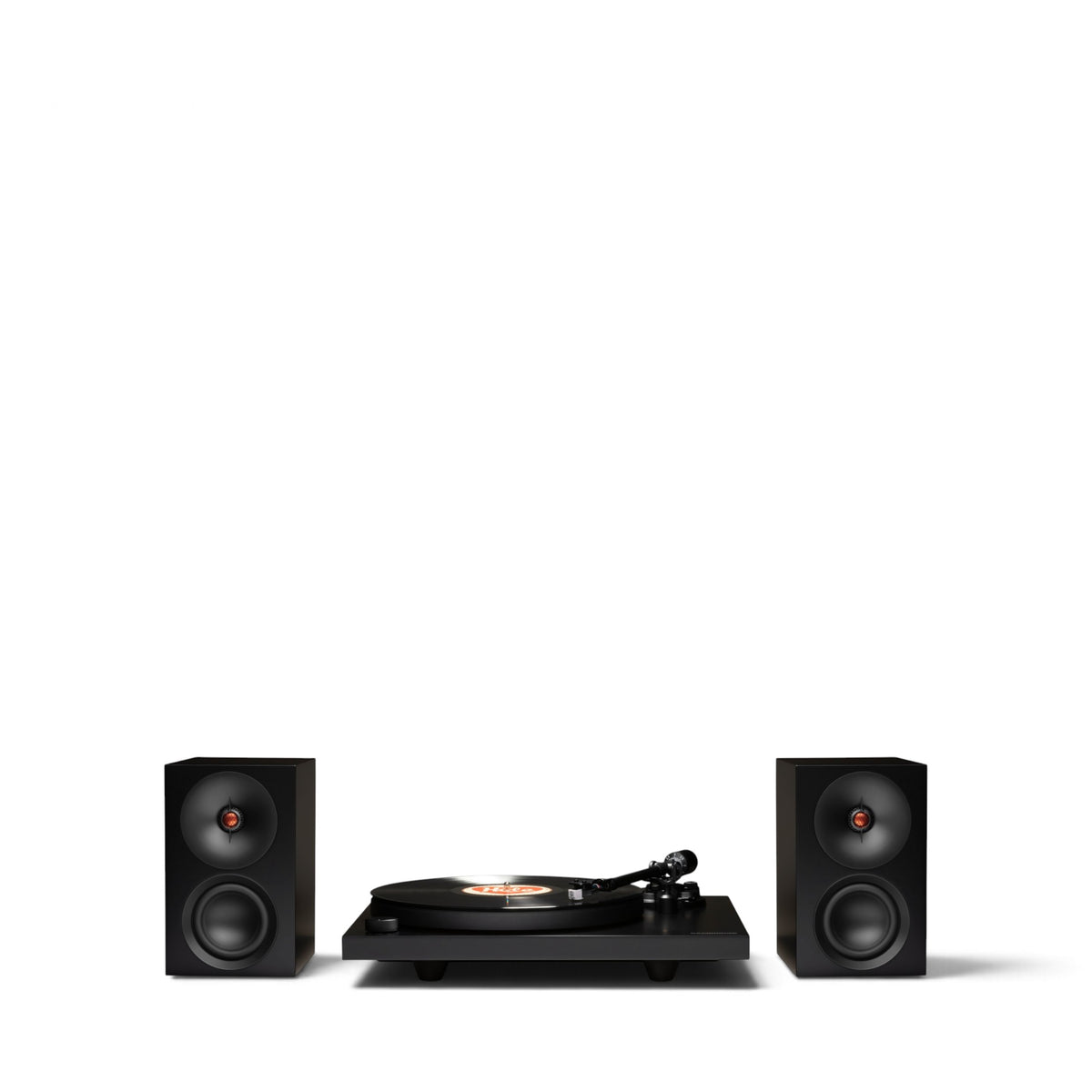 Schwarzer Cambridge Audio Spira mit aufgelegter Schallplatte zwischen zwei schwarzen L/R S Lautsprechern.
